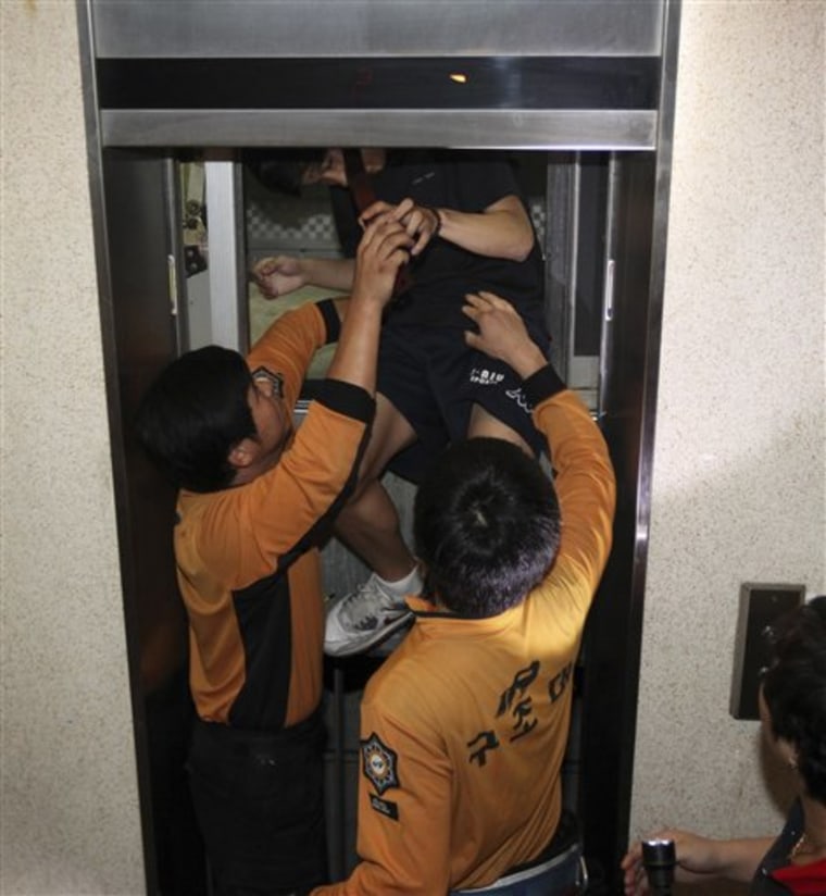 A man is freed from an elevator that stopped during power outages in Suwon, South Korea, on Thursday